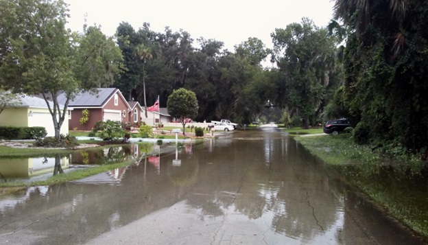 A flooded street in a suburban neighborhood.