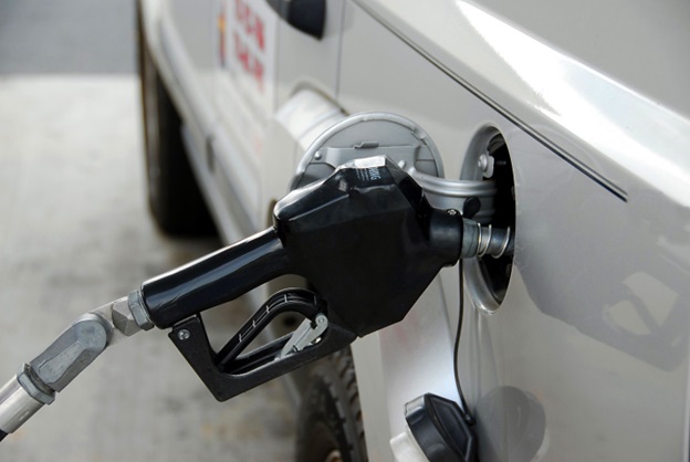 A gas pump inserted into a vehicle's gas tank at a filling station