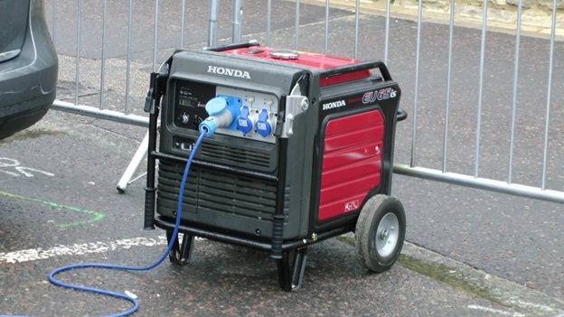 A portable generator sitting outside, with a power cable attached